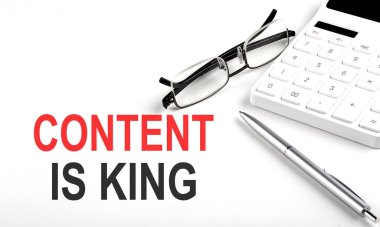 İçerik, kral kavramı. Beyaz arkaplanda hesap makinesi, kalem ve gözlük