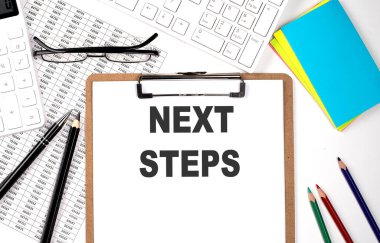 Beyaz arkaplanda NEXT STEPS ve klavye ve çizelgesi olan pano.