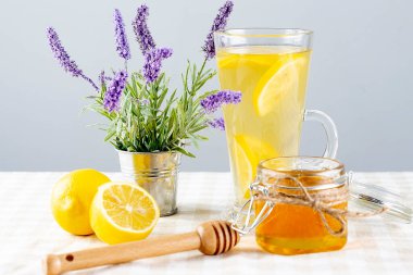 Kırsal masada limonlu, zencefilli ve ballı bir bardak çay..