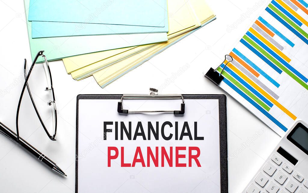 FINANCIAL PLANNER text on the paper sheet with chart,color paper and calculator