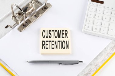 CUSTOMER RETENTION - iş konsepti, hesap makinesi ile klasör arkaplanındaki etiket üzerindeki ileti