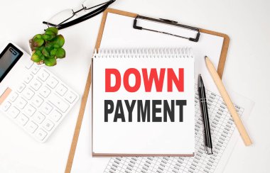 Kağıt kağıdı, not defteri, çizelgesi ve hesap makinesi olan bir ofis masası. Üst Görünüm Metni Düşük Ödeme