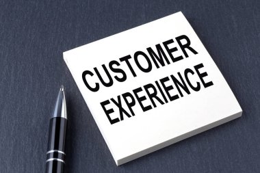 Etiketin üzerindeki siyah arkaplanda kalemle CUSTOMER ExperIENCE metni
