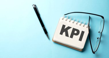 Mavi arkaplanda not defterine yazılmış KPI metni