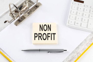 NON PROFIT - iş konsepti, hesap makineli klasör arkaplanındaki ileti