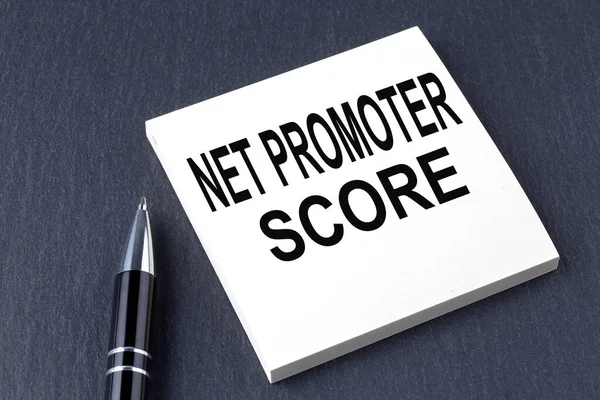 NET PROMOTER SCORE text on the sticker with pen on black background