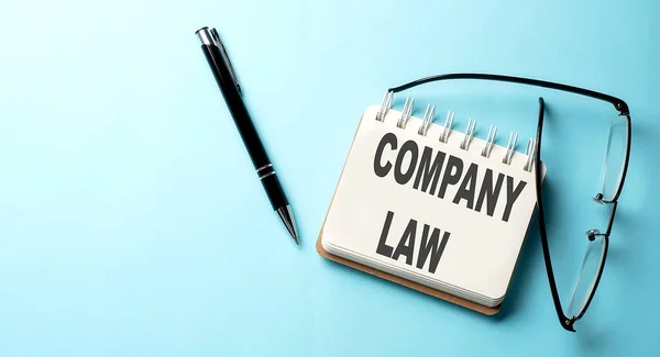 COMPANY LAW text written on notepad on the blue background