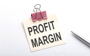 Beyaz arkaplanda kalem olan bir çıkartma üzerindeki PROFIT MARGIN metni