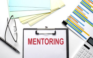 Grafik, renk kağıdı ve hesap makinesiyle kağıt üzerinde MENTORING metni