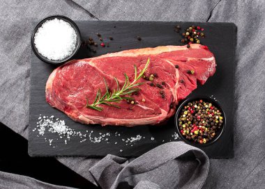 Baharatlı çiğ biftek ve gri önlüklü biberiye.