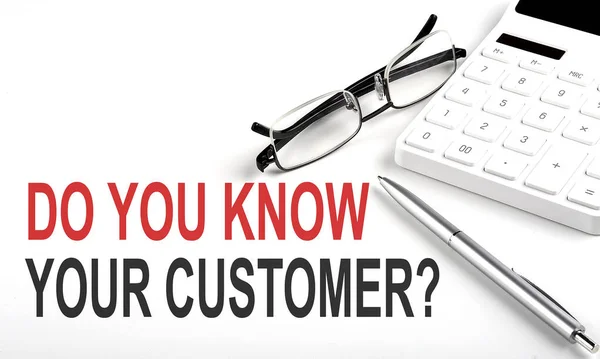 DO YOU KNOW YOUR CUSTOMER Concept. Calculator,pen and glasses on white background