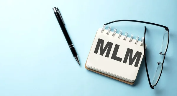 MLM text is written on notepad on the blue background