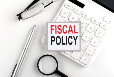 Hesap makinesi, gözlük ve büyüteçle etiketlenmiş FISCAL POLICY metni