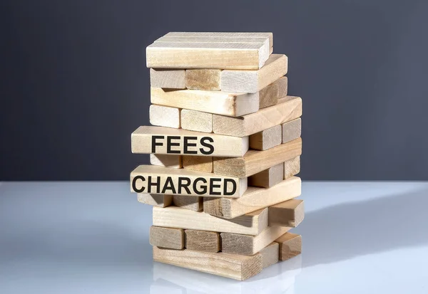 The text on wooden blocks FEES CHARGED