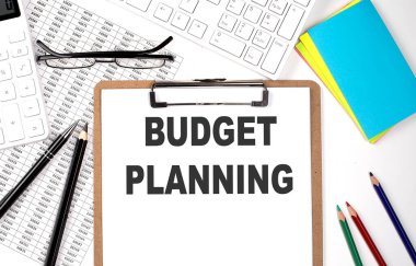 Beyaz arkaplanda metin bütçe çizimi, klavye ve grafiği olan pano.