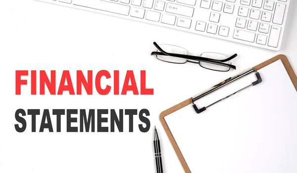 FINANCIAL STATEMENTS text written on a white background with keyboard, paper sheet and pen