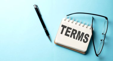 Mavi arkaplandaki not defterine yazılmış TERMS metni