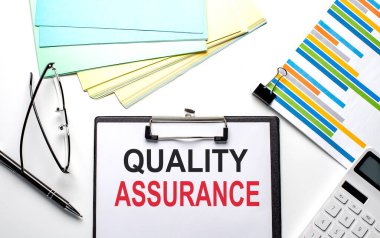 Grafik, renk kâğıdı ve hesap makinesi olan bir kağıt üzerinde nitelik asSURANCE metni
