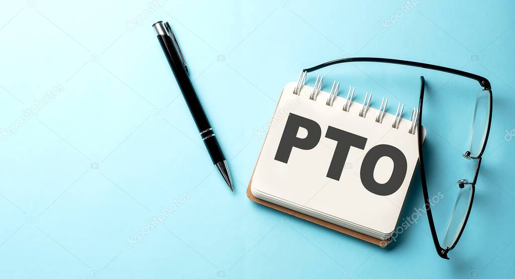 PTO text written on notepad on the blue background