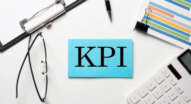Grafik, hesap makinesi ve beyaz arkaplan üzerinde KPI metni olan kağıt çıkartmaları
