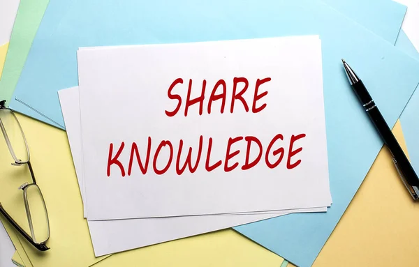 SHARE KNOWLEDGE text on a paper on the colorful paper background