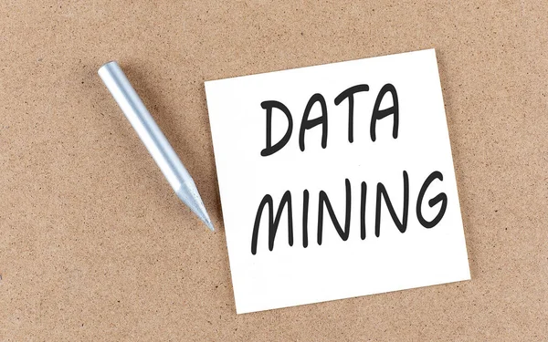 DATA MINING text on a sticky note on a cork board with pencil ,