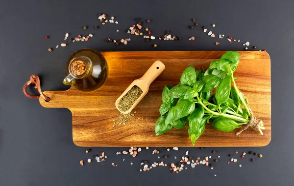 bunch of fresh organic basil in olive cutting board on rustic wooden background