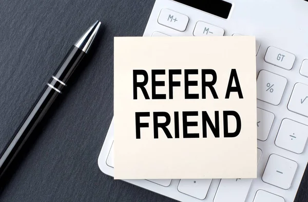 Text REFER A FRIEND on sticker on the calculator, business concept