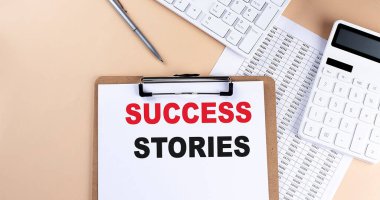 Beyaz boş kağıt metin pano SUCCESS STORIES, klavye hesap makinesi ve grafik, üst görünüm. iş