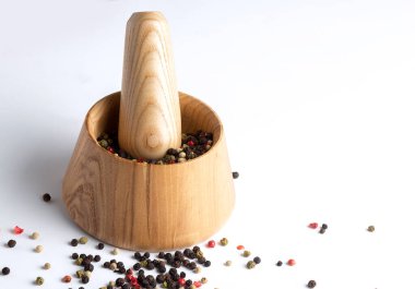 Tahta harç ve biberli tokmak beyaz bir masada karıştırılır.