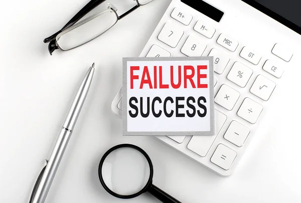 FAILURE SUCCESS text on sticker with calculator, glasses and magnifier