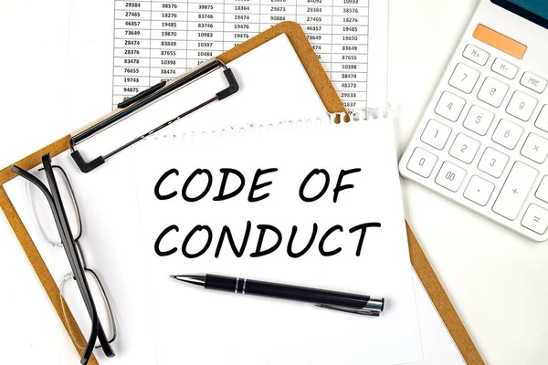 Text CODE OF CONDUCT on white paper on clipboard with chart and calculator