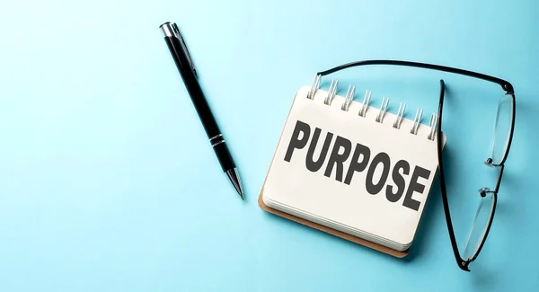 PURPOSE text written on notepad on the blue background