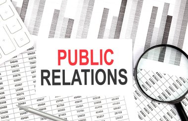 Kağıt üzerinde hesap makinesi, büyüteç ve grafik arkaplanındaki kalem ile PUBLIC İlişkileri