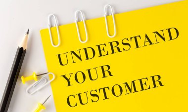 Sarı kağıdın üzerinde beyaz arka planda ofis aletleri olan 