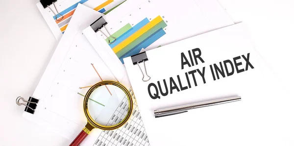 AQI Abbreviation of air quality index text on a white paper on the light background with charts paper