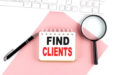 İş konsepti. Beyaz zemin içinde büyüteç, klavye ve kalem bulunan pembe kağıt üzerinde metin CLIENts 'i bulan defter