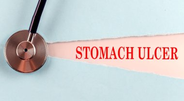 Yırtık bir kağıt üzerinde yapılmış STOMACH ULCER kelime, tıbbi konsept arka plan