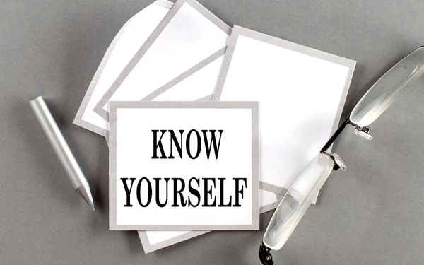 KNOW YOURSELF text written on sticky with pencil and glasses