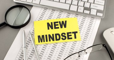 Yapışkan üzerine klavye ve büyüteçle yazılmış NEW MinDSET metni