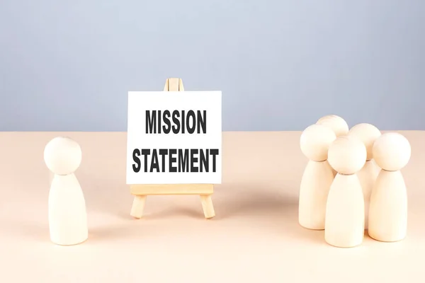 MISSION STATEMENT text on a easel with wooden figure, meeting concept