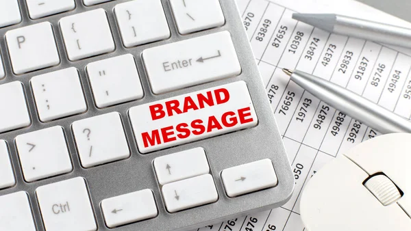 BRAND MESSAGE text on keyboard wirh chart and pencil