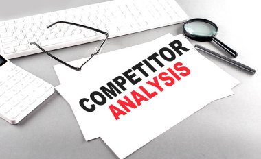 Klavyeli bir kağıt üzerinde COMPETITOR ANALYSIS metin, gri bir arkaplan üzerinde hesap makinesi