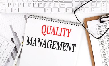 Beyaz arkaplan üzerinde klavye, not defteri ve analiz grafiği ile ofis masasında metin niteliği mantığı.