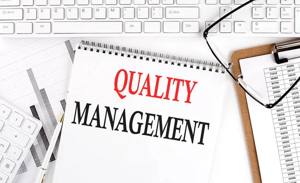 Beyaz arkaplan üzerinde klavye, not defteri ve analiz grafiği ile ofis masasında metin niteliği mantığı.