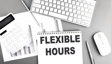 FLEXIBLE SAATTİ Gri arkaplan üzerine çizelge ve klavye ile bir deftere yazılmış metin, iş konsepti