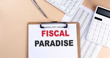 Beyaz boş kağıt metin FISCAL PARADISE, klavye hesap makinesi ve çizelgesi, üst görünüm. iş