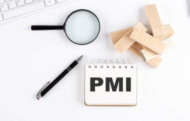 Blok büyüteç ve kalem içeren bir deftere PMI kelimesi, iş konsepti.