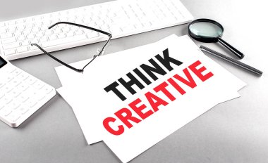 Hesap makinesi ve beyaz klavyenin yanında gri arkaplan üzerine yaratıcı bir metin düşünün