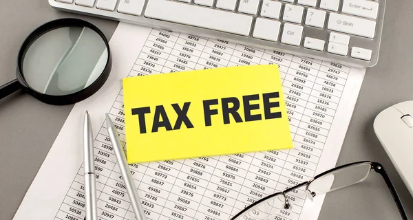 TAX FREE text written on sticky on chart with keyboard and magnifier